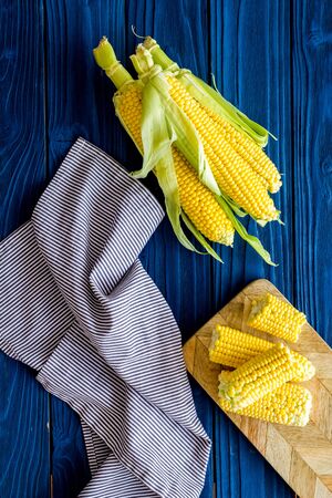 Ripe corn on cobs on blue wooden table background top viewの写真素材