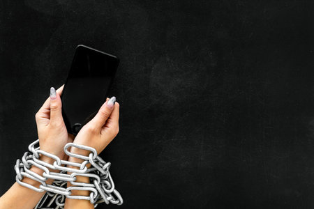 Protection from cyber attack with cell phone in hands and chain on black background top view...