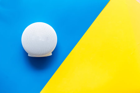 Portable wireless speakers as gadgets for listen to the music on blue and yellow background top view...