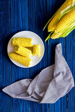 Corn on cobs and on plate on blue wooden background top viewの写真素材