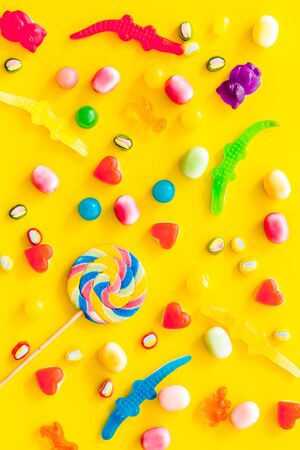 Candies for party design on yellow background top viewの写真素材