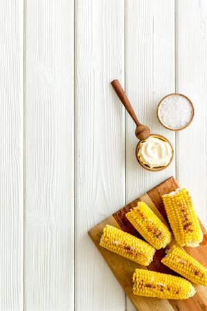 Corn fried on grill with salt and butter on white wooden table background top view mock upの写真素材