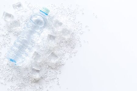 Pile of ice cubes and bottle on white bar desk background top view copyspaceの写真素材