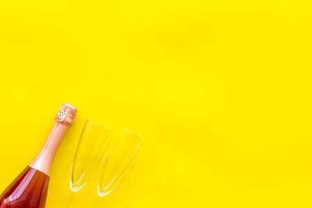 Champagne bottle with glasses for celebration on yellow background top view mock upの写真素材
