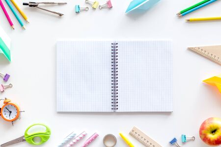 Student accessories frame around textbook on pupils desk white background top view mockupの写真素材
