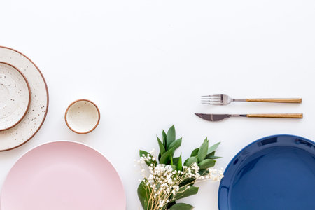Elegant table setting with plates and tableware on white background top view copyspace