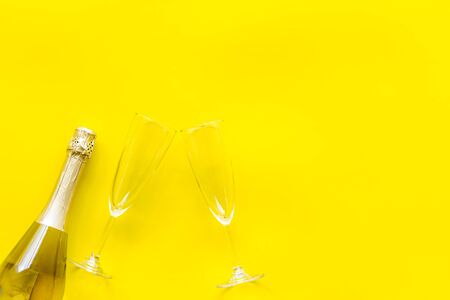 Champagne bottle with glasses for celebration on yellow background top view mock upの写真素材