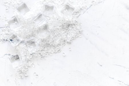 Pile of ice cubes on marble bar desk background top view mockupの写真素材