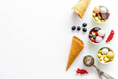 summer dessert with ice cream, cones, fruit, berries and nuts on white backgroung top view mock upの写真素材