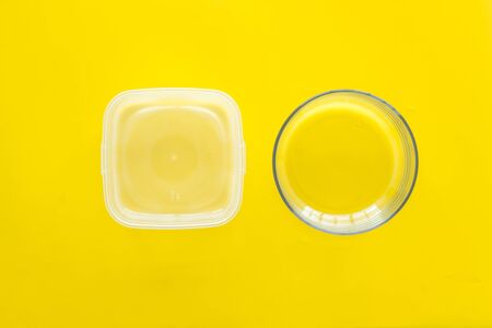 empty food container and bowl on yellow wooden background top viewの写真素材