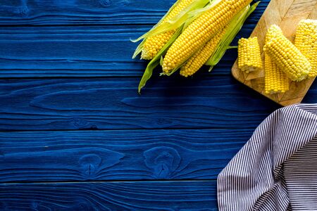 Corn on cobs on blue wooden background top view copyspaceの写真素材