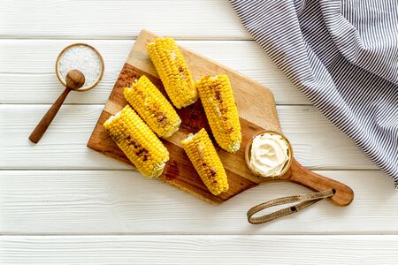 Fried corn on board with salt and butter on white wooden background top viewの写真素材