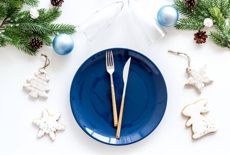 Table setting for new year 2020 celebration with pine branch, decorations, plate and tableware white background top viewの写真素材