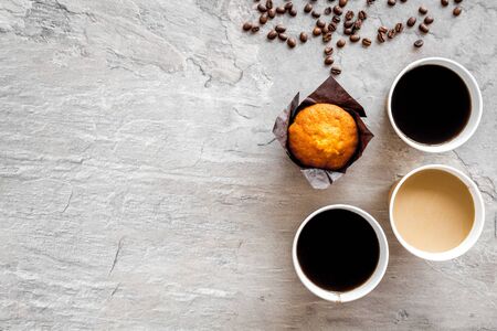 Breakfast with muffin and coffee to-go on gray background top view mockupの写真素材