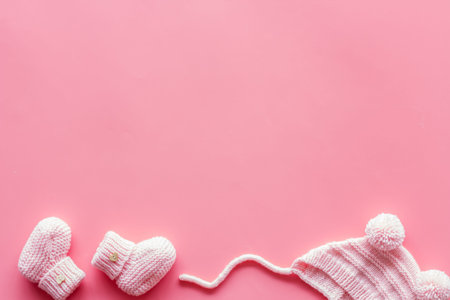 Pink knitted set for kids on pink background top view space for textの写真素材