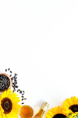 Fresh sunflower oil with seeds and flower frame on white background top view mock upの写真素材