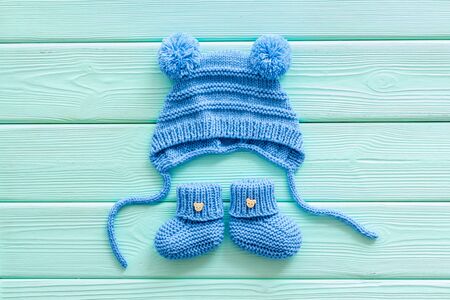 Booties and hat for newborn boy on mint green wooden background top viewの写真素材
