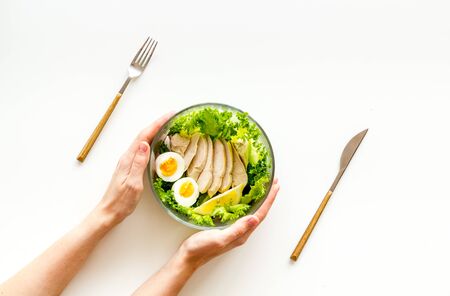 Healthy dinner in bowl in hands on white background top viewの写真素材