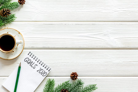 New Year goals concept. Notebook near New Year decoration like spruce branch and gifts.