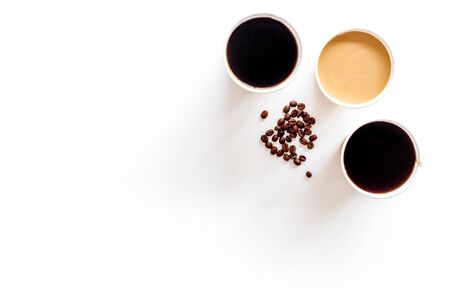 Coffee to take away in paper cups with coffee beans on white table background top view space for textの写真素材