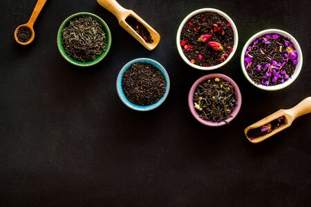 Assortment of dry tea in bowls frame on black background top view copyspaceの写真素材