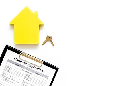 House mortgage with application, house toy, keys on white banker desk background top view mock upの写真素材