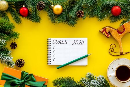 Planning New Year 2020. Notebook with goals on yellow background top viewの写真素材