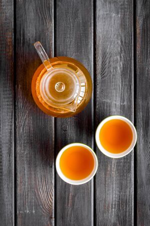 Cups and teapot with brew on wooden background top viewの写真素材