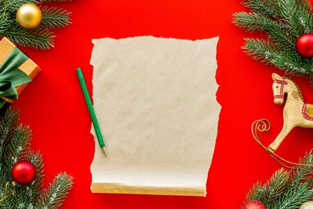Letter to Santa Claus concept. Paper on red background with New Year decoration top view mockup space for textの写真素材