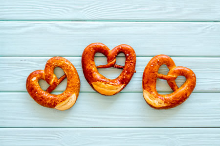 Octoberfest symbol. Fresh bavarian pretzels on blue wooden background top view copy spaceの写真素材