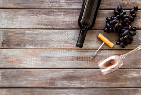 Red wine bottle near grape, wineglass and corkscrewの写真素材