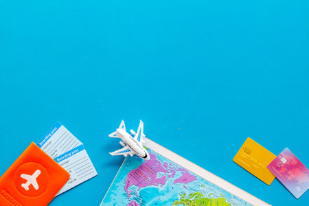 Tourism or vacation background with world map and tickets on blue table top view.