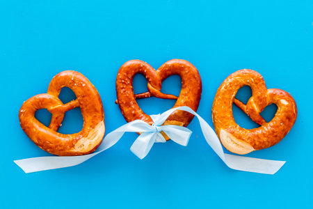 Octoberfest symbol. Fresh bavarian pretzels on blue background top view