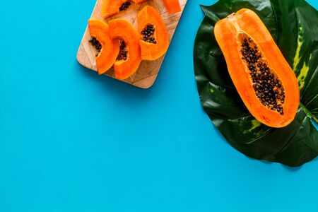Papaya slices on blue background top view copy spaceの写真素材