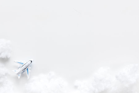 Fly by plane concept. Airplane model and clouds on white background top view frame space for text