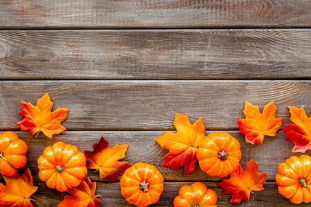 Autumn background with leaves and pumpkins on dark wooden top view space for text frame