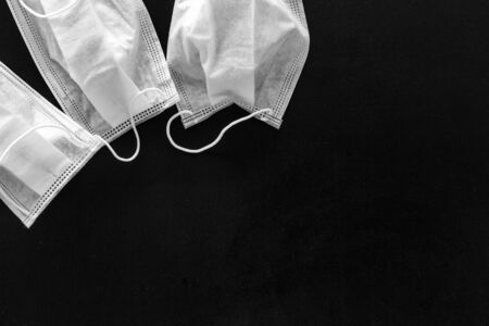 Flu prevention concept. Medical face mask on black background top view space for text frameの写真素材