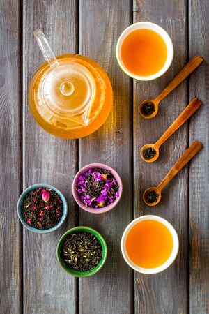 Tea ceremony. Cups, teapot, dry tea on wooden background top view patternの写真素材