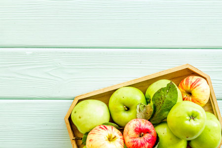 Healthy diet concept. Fresh apples in tray on green wooden background top view.