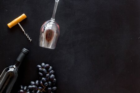 Red wine bottle near wineglass on black background top view space for textの写真素材