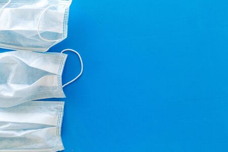 Flu prevention concept. Medical face mask on blue background top view space for text frameの写真素材