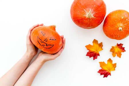 Make pumpkin decoration for Halloween. Pumpkin in hands on white background top viewの写真素材