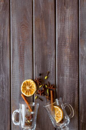Mulled wine concept. Spices and dried orange in glasses on dark wooden background top view copy spaceの写真素材