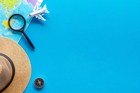 Travelling background with tourist accessories and world map on blue top view space for text frameの写真素材