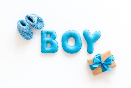 Childrens birthday concept. Word boy near booties and present box on white background top viewの写真素材