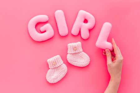 Decoration for babys birthday. Word girl near booties on pink background top viewの写真素材