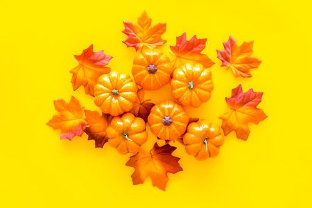 Red and orange leaves near pumpkins top view