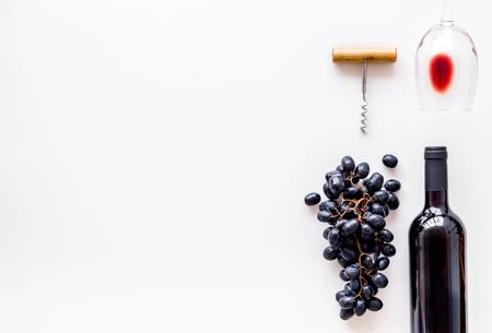 Red wine bottle near grape, wineglass and corkscrewの写真素材