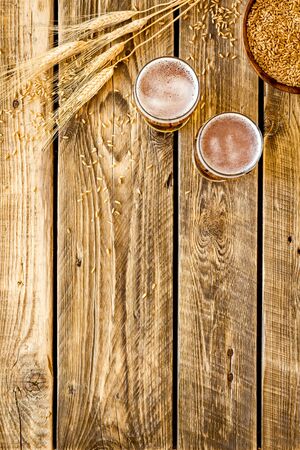 Barley or wheat as beer ingredient near beer glasses on rustic wooden background top view copy spaceの写真素材
