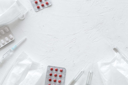 Treat flu and cold concept. Vaccine, mask, pills on white background top view frame copy spaceの写真素材